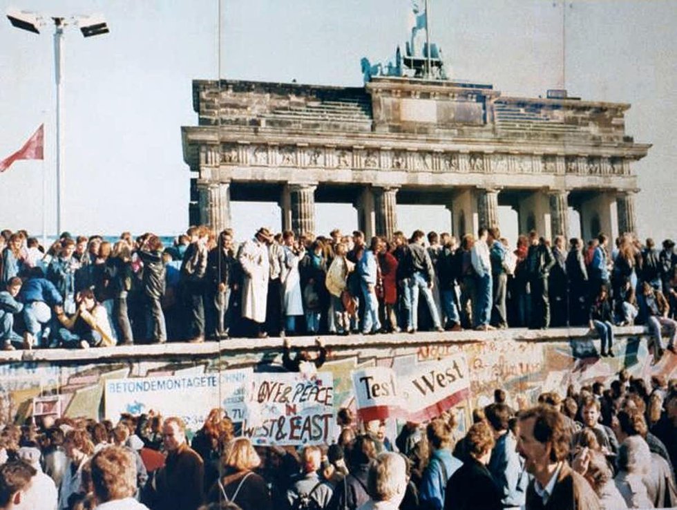 Crowds stand atop the Berlin Wall