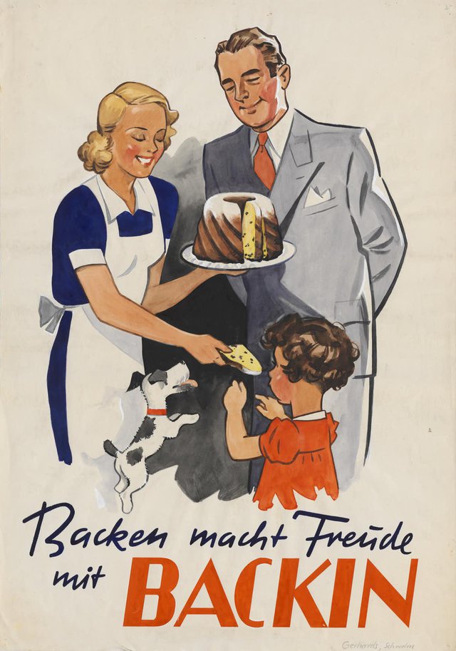 A woman in an apron stands next to a suited man. The woman gives some cake to a child, standing in front of them.