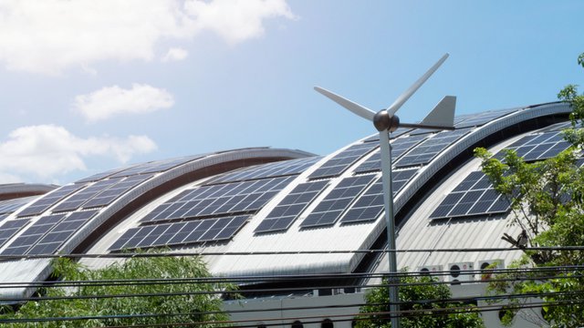 Solar panels and windmill on building rooftop